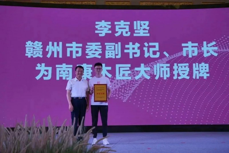 李克堅為2022年世界技能大賽特別賽家具制作項目冠軍李德鑫頒發(fā)南康木匠大師，為贛州現(xiàn)代家居產(chǎn)業(yè)發(fā)展戰(zhàn)略顧問頒發(fā)聘書