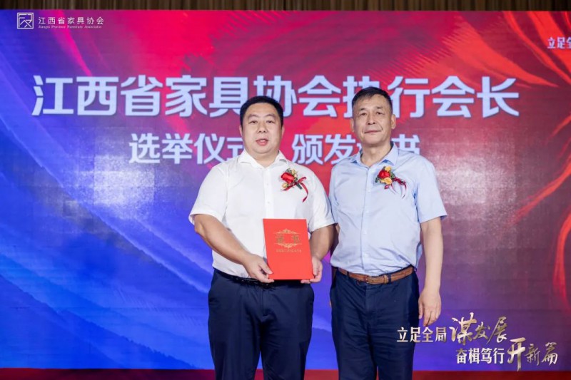 江西省家具協(xié)會(huì)會(huì)長劉偉為新當(dāng)選的江西省家具協(xié)會(huì)執(zhí)行會(huì)長顧建廈頒發(fā)《當(dāng)選榮譽(yù)證書》
